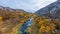 A picturesque stream flows in the Aktovsky Canyon, surrounded by autumn trees and large stone boulders