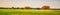 Picturesque summer landscape with beveled meadow and haystacks in cloudy morning. Hay harvest at farmland. Beautiful agricultural