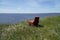 Picturesque Summer landscape with red old armchair on a high bank with a beautiful view of the Volga River