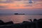 Picturesque sunset near the sea with ship, rocks, horizon, fisherman and orange clouds. Phu Quoc, Vietnam.