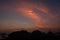 A picturesque sunset over the sea with a dark silhouette of the rocks.