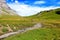 Picturesque Swiss Alpine landscape with grazing cows against the backdrop of high mountains