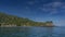 A picturesque tropical island against a background of blue sky and clouds.