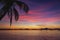 Picturesque tropical sunset. Dramatic evening sky above island. Palm tree and isles silhouettes. Exotic seascape in twilight.