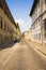 A picturesque and typical street of Florence with motorcycles and cars.