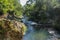 Picturesque valley in mountains and calm river. Boulders in the riverbed and rocks along the valley.