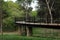 Picturesque view of bridge with metal railing and many trees in park