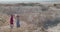 Picturesque view of duet of violinists in blowing dresses play music on cliffs