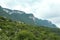 Picturesque view of estate near big mountains and trees under cloudy sky