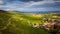 Picturesque view of Kaysersberg in summertime, featuring lush vineyards and sprawling farmland