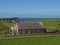 Picturesque view of a majestic church against a vast backdrop of verdant fields, Shetlands Island,