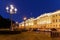 A picturesque view of the Neva embankment and the facades of houses in the light of lanterns in St. Petersburg in the