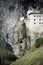 Picturesque view of the Predjama Castle situated in the middle of a towering cliff in Slovenia