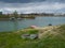 Picturesque view of the river with fishing boats along the shore and huts along the river island during a gloomy cloudy day