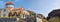 Picturesque view of a rustic orange and white church perched atop a grassy hill in Crete