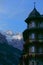 Picturesque view of the snowy mountain range behind a lovely rustic hotel.