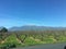 Picturesque view of spring garden without leaves on mountain Olimp background and blue sky, Greece