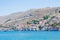 Picturesque view on tiny colorful houses on rocks near the Mediterranian sea on Greek island in sunny summer day