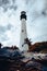 Picturesque vista of the Cape Florida Lighthouse atop a lush green hill, surrounded by palm trees