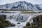 Picturesque waterfal Tungnaarfellsfoss, Iceland, panoramic autumn view  Landmannalaugar mountains under snow cover in far