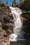 A picturesque waterfall flowing from a mountain gorge.One of the six waterfalls of the Podkomarnaya River,Siberia,Russia