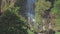 Picturesque waterfall from high rocky cliff with green trees