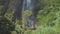 Picturesque waterfall from high rocky cliff with green trees