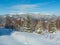 Picturesque winter morning mountains view from young fir and birch forest. Skupova mountain alpine slope, Verkhovyna district,