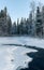 Picturesque winter scene of a stream meandering through a pristine, snowy forest