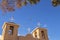 Pidgeons flying above the roof and bell towers of the famous adobe San Francisco de Asis Mission Church on the main plaza of Ranch