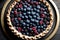 A pie with berries and blueberries on a plate.
