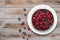 Pie with berries top view: raspberry, currant, strawberry on a white plate on a wooden background, near red currant and