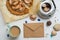 Pie, envelope, seashells, potter and coffee cup on white wooden table. Flat lay food