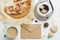 Pie, envelope, seashells, potter and coffee cup on white wooden table. Flat lay food