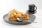 Piece of an apple pie with ice cream and cup of coffee espresso on white wooden table
