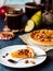 Piece of apple tart on a round plate, spoon caramel