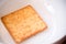 Piece of baked salty whole wheat crispy thin cracker in the white bowl. delicious snack for after breakfast, tea break afternoon.