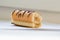 Piece biscuit cake mini roll with cream and chocolate pattern on light background,