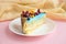 Piece of biscuit patterned cake with blue mastic and decor fruit