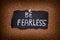 Piece of black paper with phrase Be Fearless