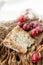 A piece of blue Stilton cheese on a wooden antique background with large red grapes. Close up