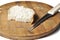 A piece of bread and a knife on a wooden board isolated on a white background