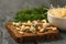 A piece of bread with sprouts and a bowl of mung beans on a black table