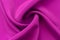 A piece of burgundy, violet, red cloth. Fabric texture for background and design works of art, beautiful wrinkled pattern of silk