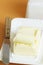 A piece of butter in butter dish and a knife on a colored background.