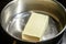 A piece of butter is melted in a steel saucepan