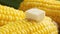 Piece of butter is melting on the hot cob of corn