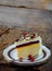 Piece of cake `Napoleon`: crispy cakes with cream, orange cream, cranberry jelly, cheese mousse. Side view.