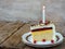 Piece of cake `Napoleon` with lighted candles. Birthday. Side view. Copy space.