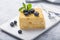 Piece of cake Napoleon on white plate on concrete              background, close up view. Traditional millefeuille dessert with